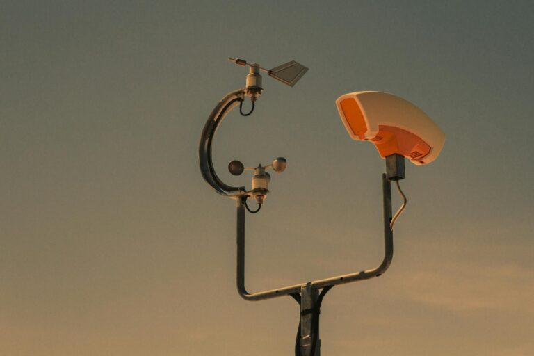 Weather monitoring equipment with a sunset sky backdrop, highlighting technology and atmosphere.